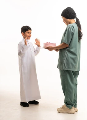Domestic Worker Giving Cake to Saudi Boy in Thobe