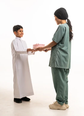 طفل سعودي وعاملة منزلية مع كعكة على خلفية بيضاء طفل سعودي وعاملة منزلية مع كعكة على خلفية بيضاء