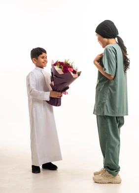 طفل سعودي يهدي زهور لعاملة منزلية خلفية بيضاء