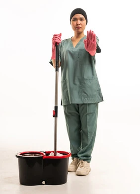 عاملة نظافة آسيوية مع ممسحة وإيماءة توقف باليد