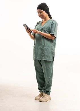 عاملة منزلية آسيوية بالزي الرسمي تستخدم الجوال