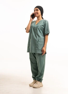 عاملة منزلية آسيوية تتحدث بالهاتف بزي العمل