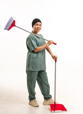 عاملة نظافة آسيوية بالزي الرسمي مع مكنسة