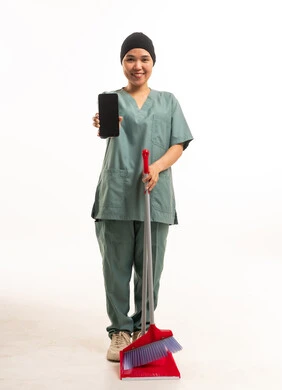 عاملة منزلية آسيوية تحمل هاتف ذكي ومكنسة