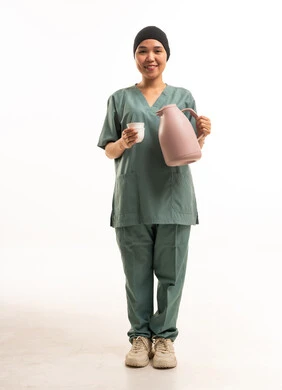 عاملة صحية آسيوية بزي العمل الأخضر مع القهوة