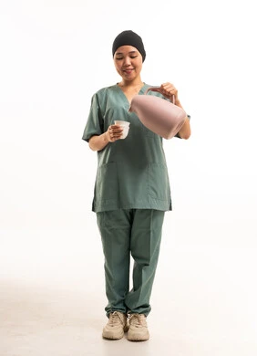 عاملة منزلية آسيوية تصب مشروباً من ترمس وردي