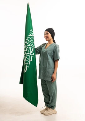 عاملة منزلية تحمل العلم السعودي بخلفية بيضاء