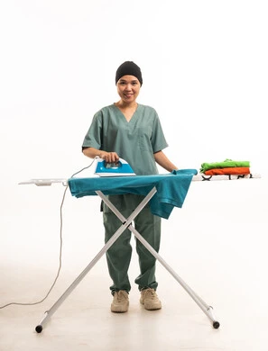 عاملة منزلية آسيوية تقوم بكي الملابس على خلفية بيضاء عاملة منزلية آسيوية تقوم بكي الملابس على خلفية بيضاء