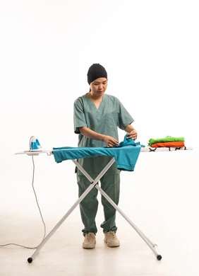 East Asian Domestic Worker Ironing Clothes in Studio