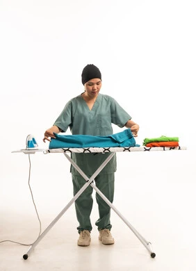 عاملة منزلية فلبينية تقوم بكي الملابس في الاستوديو