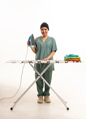 عاملة منزلية آسيوية مع مكواة ملابس وطاولة كي