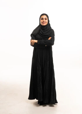 امرأة سعودية بعباءة سوداء بخلفية بيضاء