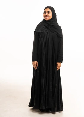 امرأة سعودية بالعباءة السوداء على خلفية بيضاء