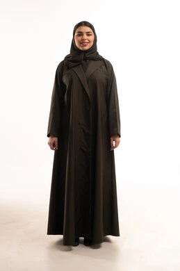 امرأة سعودية بعباءة بنية على خلفية بيضاء