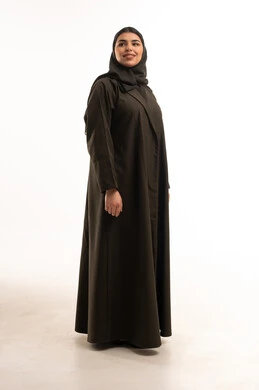 امرأة سعودية بعباية زيتونية تقليدية على خلفية بيضاء