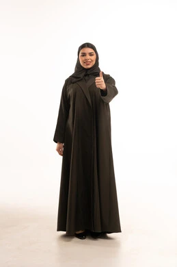 امرأة سعودية بعباءة سوداء وإيماءة الإبهام للأعلى