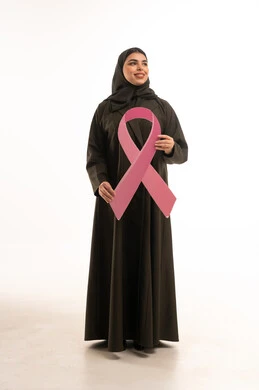 امرأة سعودية تحمل الشريط الوردي للتوعية بسرطان الثدي