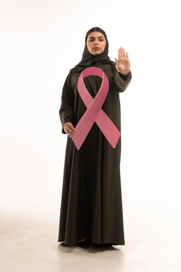 امرأة سعودية مع شريط وردي وإشارة توقف للتوعية