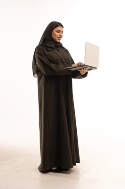 امرأة سعودية بالعباءة تستخدم الحاسوب المحمول في استوديو