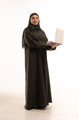 امرأة سعودية بالعباءة تستخدم الحاسوب المحمول
