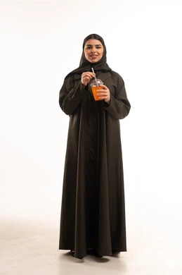 Saudi Woman in Abaya Holding Orange Juice in Studio