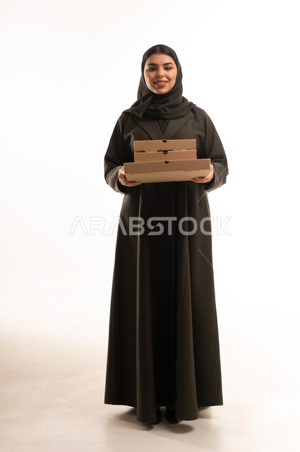 امرأة سعودية تحمل علب بيتزا على خلفية بيضاء