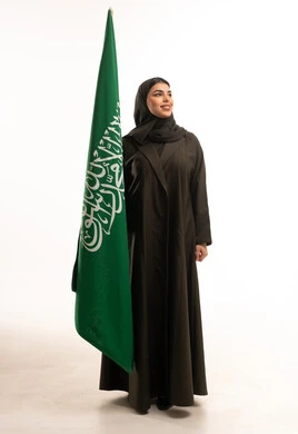 امرأة سعودية تحمل العلم الوطني بخلفية بيضاء