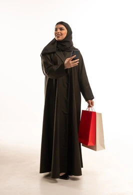Saudi Woman with Shopping Bags Using Smartphone