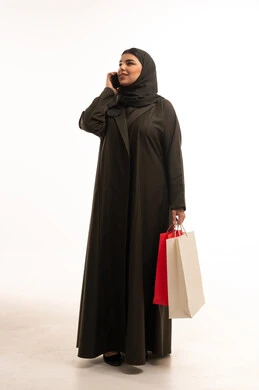 Saudi Woman with Shopping Bags Talking on Smartphone