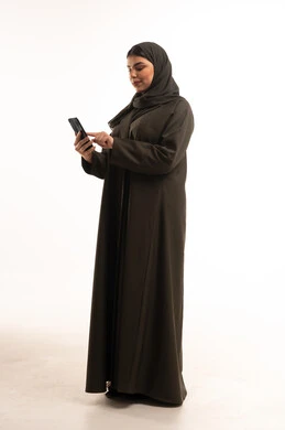 Saudi Woman in Abaya Using Smartphone in Studio