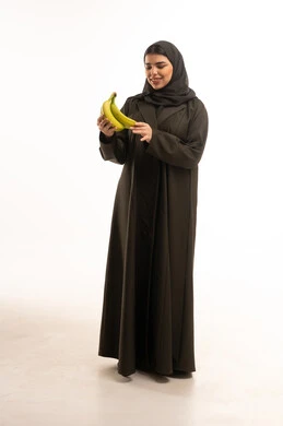 Saudi Woman in Black Abaya Holding Green Bananas