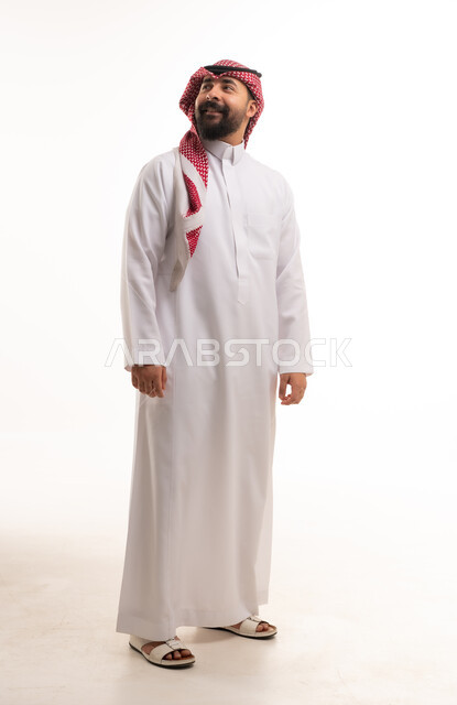 رجل سعودي بالثوب التقليدي أمام خلفية بيضاء