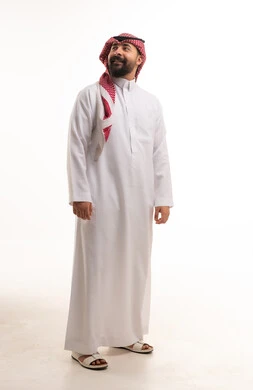 رجل سعودي بالثوب التقليدي أمام خلفية بيضاء