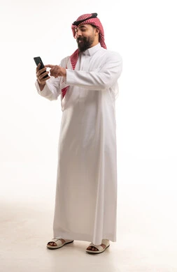 Saudi Man in Traditional Thobe Using Smartphone on White