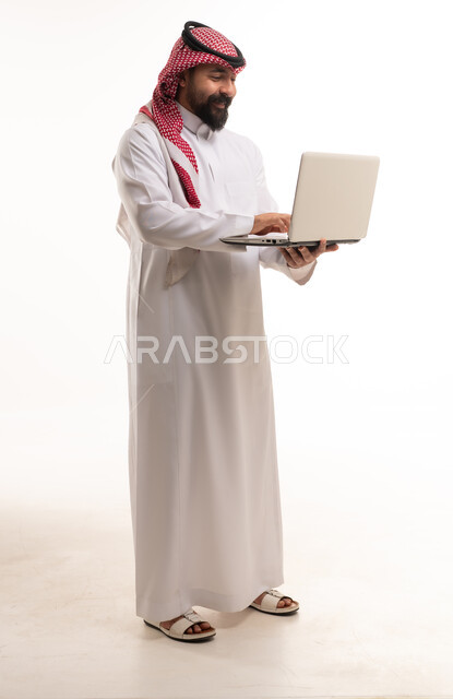 Saudi Man in Traditional Thobe Using Laptop