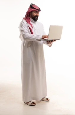 Saudi Man in Traditional Thobe Using Laptop