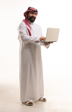 Saudi Man in Traditional Thobe Using Laptop
