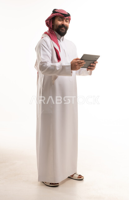 Saudi Man in Traditional Thobe Holding Digital Tablet