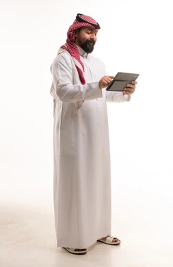 رجل سعودي بالثوب يستخدم جهاز لوحي رقمي في الاستوديو