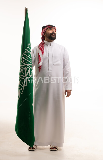 رجل سعودي يحمل علم السعودية بخلفية بيضاء