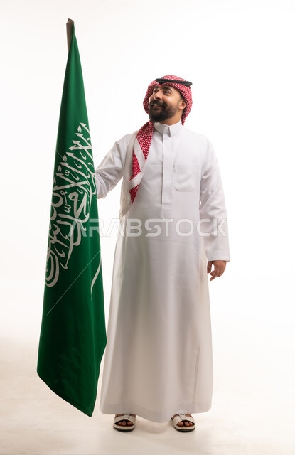 Saudi Man Holding Saudi Arabia National Flag in Studio