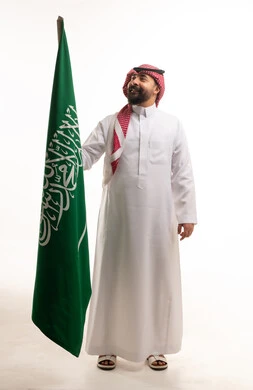 Saudi Man Holding Saudi Arabia National Flag in Studio