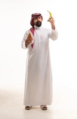 رجل سعودي يختار بين البيتزا والموز بخلفية بيضاء