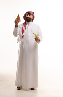 رجل سعودي يقارن بين البيتزا والموز بخلفية بيضاء