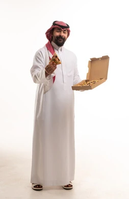 رجل سعودي يحمل شريحة بيتزا وعلبة طعام