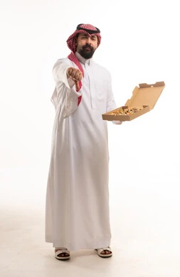 رجل سعودي يشير بعدم الرضا عن وجبة بيتزا