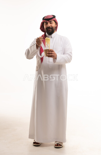 رجل سعودي يأكل معكرونة سريعة التحضير بالاستوديو