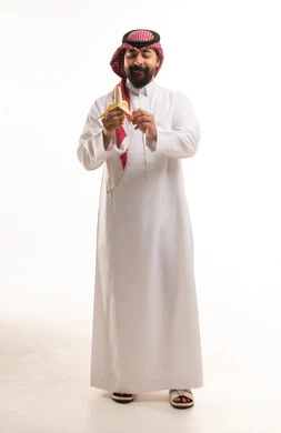 Saudi Man in Traditional Thobe Peeling a Banana