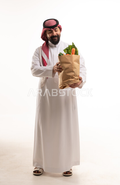 رجل سعودي يحمل كيس خضروات طازجة