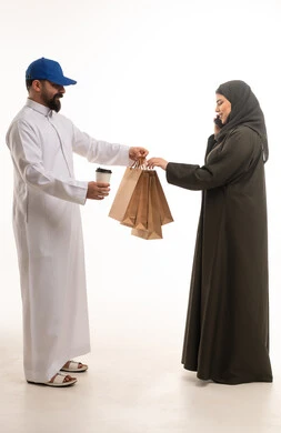 رجل سعودي يسلم حقائب تسوق لامرأة عربية
